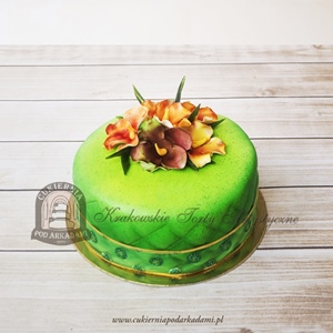 Tort z zieloną polewą zdobiony ręcznie wykonanymi kwiatami