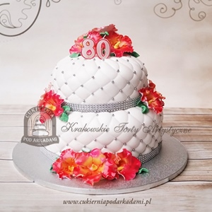 Piętrowy tort urodzinowy z pikowaną polewą, zdobiony ręcznie wykonanymi i malowanymi kwiatami, srebrnymi koralikami i kryształową tasiemką