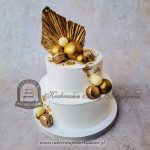 435BA Biało-złoty tort piętrowy zdobiony złotymi makaronikami kulami złotkiem i palmowym liściem
